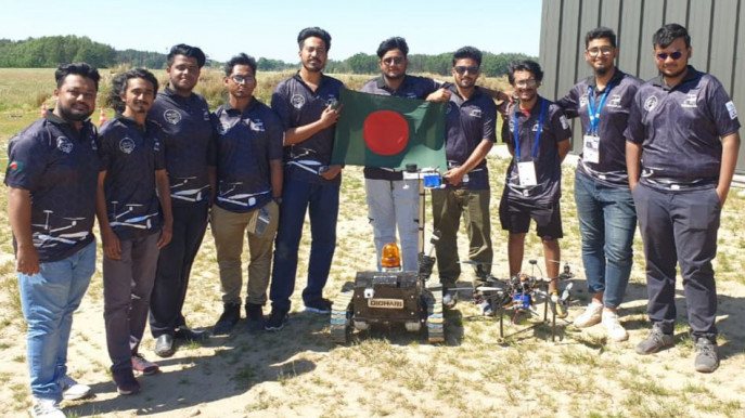 The BRACU Dichari team holding the Bangladesh flag beside their rover and drone on a field in Poland